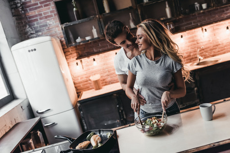 Attractive couple is cooking on kitchen.の写真素材
