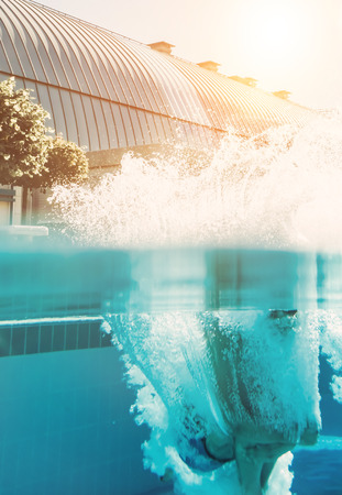 Man is jumping into the swimming pool. Man under water.の写真素材