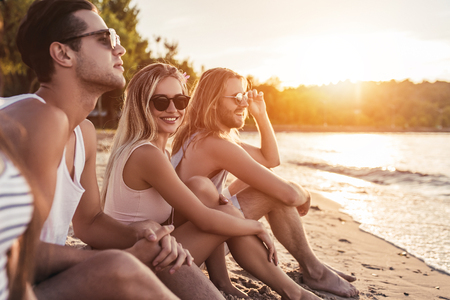 Group of young attractive friends are having fun on beach and smiling.の写真素材