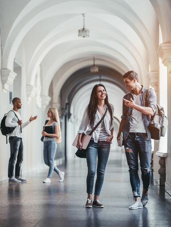 Multiracial students are walking in university hall during break and communicating.の写真素材