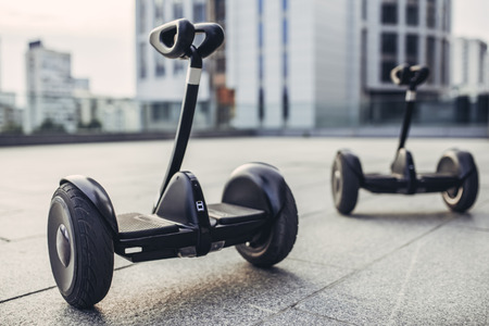 Two gyro scooters are standing on the street. Couple of gyro scooters in the background of city.の写真素材
