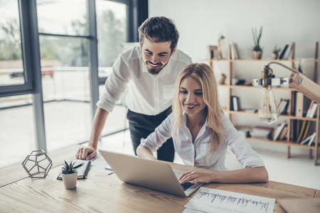 Attractive young businessman and businesswoman are working in modern light office.の写真素材