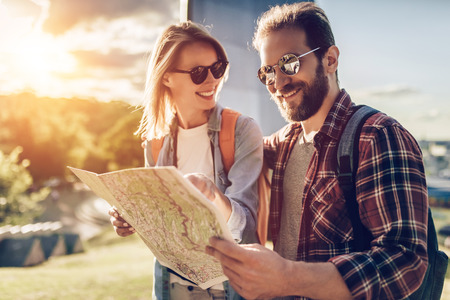 Couple of tourists is exploring new city together with map in hands.の写真素材