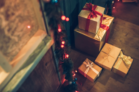 Cropped image of decorated house facade with presents from Santa Claus before Christmas. Gift boxes are lying on the porch in New Year Eve.の写真素材