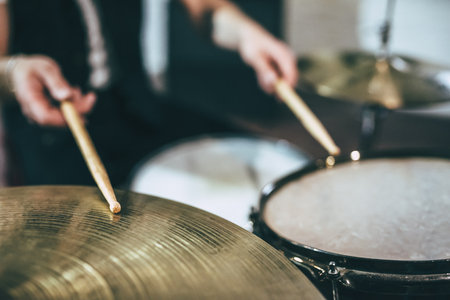 Repetition of rock music band. Cropped image of drummer behind the drum set. Rehearsal base
