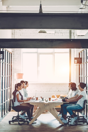 Multiracial young creative people in modern office. Group of young business people are working together with laptop, tablet, smart phone, notebook. Successful hipster team in coworking. Freelancers.の写真素材