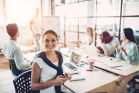 Multiracial young creative people in modern office. Group of young business people are working together with laptop, tablet, smart phone, notebook. Successful hipster team in coworking. Freelancers.の写真素材