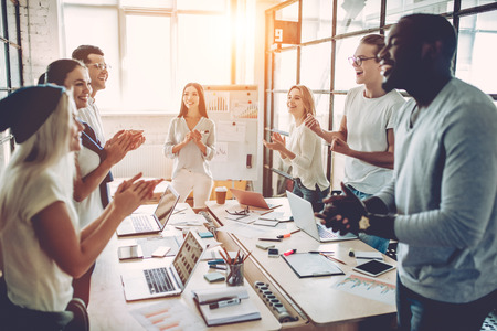 Multiracial young creative people in modern office. Group of young business people are working together with laptop, tablet, smart phone, notebook. Successful hipster team in coworking. Freelancers.の写真素材