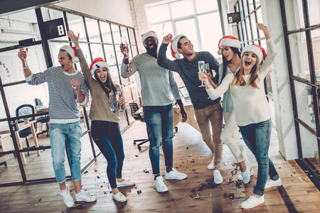 Merry Christmas and Happy New Year 2018!Multiracial young creative people are celebrating holiday in modern office.の写真素材