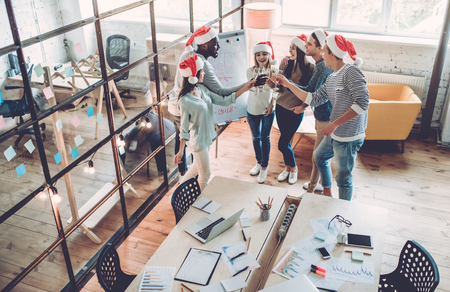 Merry Christmas and Happy New Year 2018!Multiracial young creative people are celebrating holiday in modern office.の写真素材
