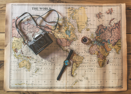 Top view of world map with tourist attributes. Watch, compass and retro camera are lying from above.の写真素材