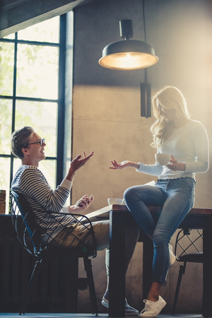 Handsome young man and attractive young woman are spending time together. Romantic couple is working in cafe. Taking coffee break and communicating.の写真素材