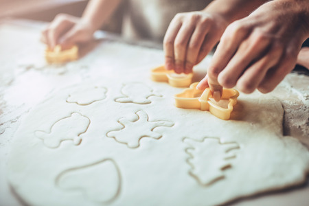 Cropped image of attractive young woman and her little cute daughter are cooking on kitchen. Having fun together while making cakes and cookies.の写真素材