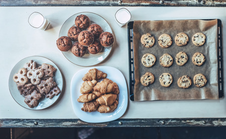 Top view of freshly baked pastries lying on table. Cookies, cakes, 
croissants.の写真素材