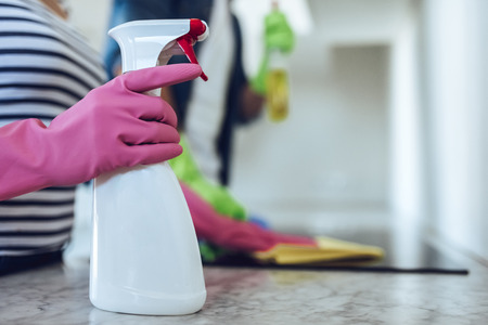 Cropped image of young happy couple is washing kitchen while doing cleaning at home.の写真素材