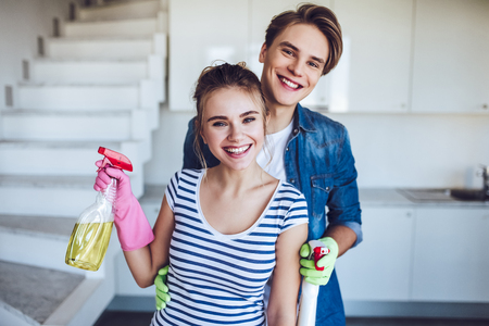 Young happy couple is washing kitchen while doing cleaning at home.の写真素材