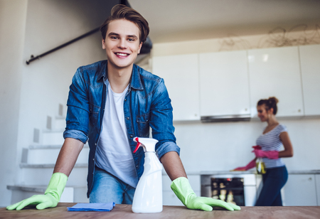 Young happy couple is washing kitchen while doing cleaning at home.の写真素材