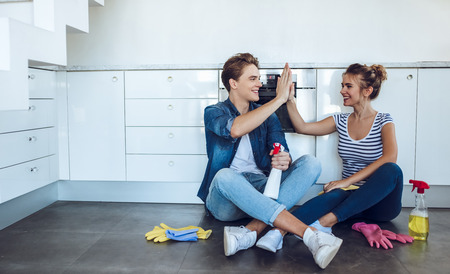 Young happy couple is having rest after doing cleaning at home.