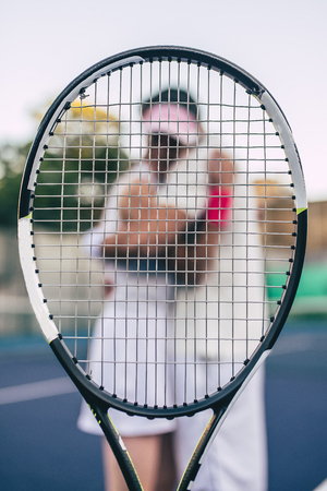 Young couple on tennis court. Handsome man and attractive woman are playing tennis. Hugging.の写真素材