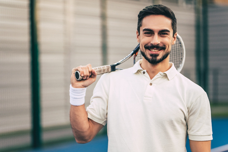 Handsome man on tennis court. Young male tennis player.の写真素材