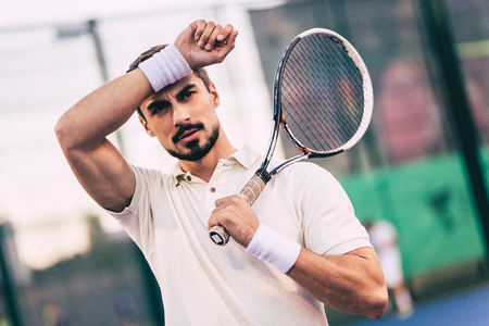 Handsome man on tennis court. Young male tennis player.の写真素材