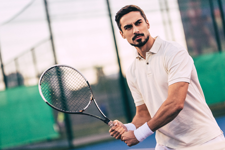 Handsome man on tennis court. Young male tennis player.の写真素材