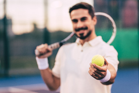 Handsome man on tennis court. Young male tennis player.の写真素材