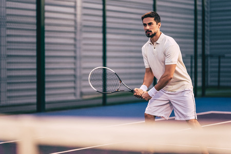 Handsome man on tennis court. Young male tennis player.の写真素材