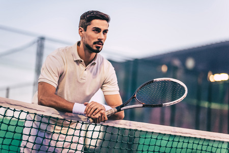 Handsome man on tennis court. Young male tennis player.の写真素材