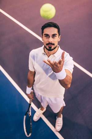 Handsome man on tennis court. Young male tennis player.の写真素材