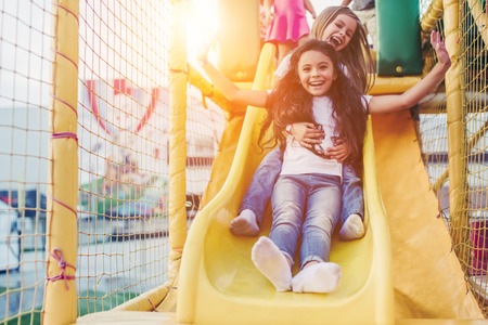 Little pretty girls having fun outdoor. Playing in children zone in amusement park.の写真素材