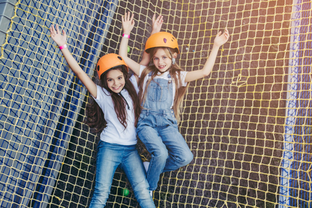 Little pretty girls having fun outdoor. Playing in children zone in amusement park.の写真素材