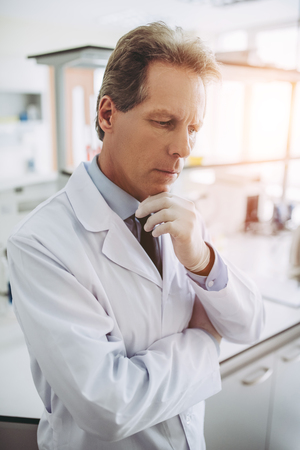 Senior experienced scientist is working in laboratory. Pensive doctor in clinic.の写真素材