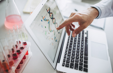 Cropped image of senior experienced scientist is working in laboratory. Doing investigations using laptop.の写真素材