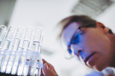 Senior experienced scientist is working in laboratory. Doing investigations with test tubes.の写真素材