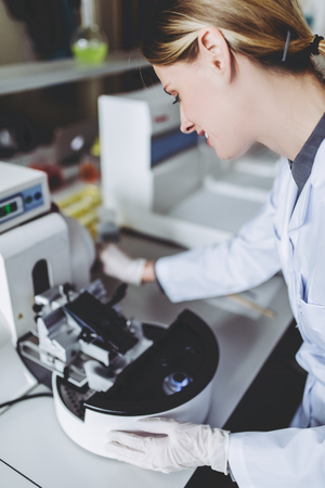 Scientist is working in laboratory. Young female researcher is doing investigations on laboratory equipment.の写真素材