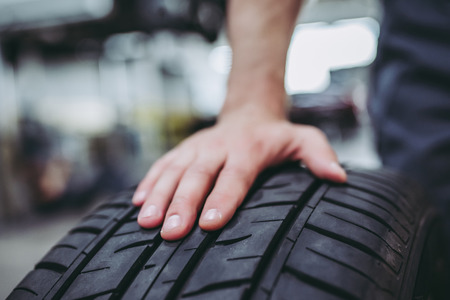Cropped image of handsome mechanic in uniform is working in auto service. Car repair and...