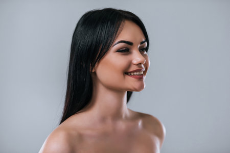 Portrait of attractive young woman looking to the side on grey background. Women careの写真素材