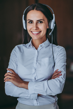How can I help you?Portrait of attractive female call center worker in headphones is smiling and looking at the camera.の写真素材