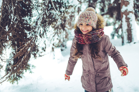 Little cute girl is having fun outdoots in winter.の写真素材