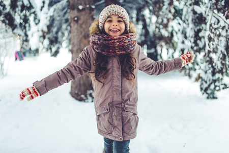 Little cute girl is having fun outdoots in winter.の写真素材