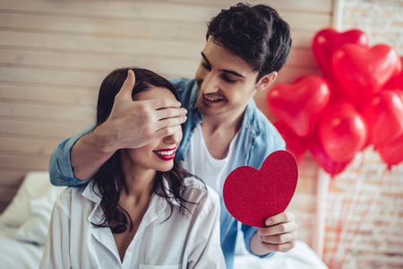 Beautiful young couple in bedroom. Celebrating Saint Valentine's Day.の写真素材