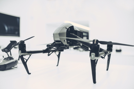 Light white store with modern devices. Quadcopters, glasses of virtual reality, camera with...