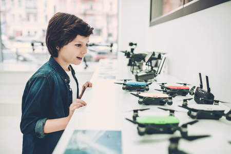 Cute little boy in modern light quadcopter store.の写真素材