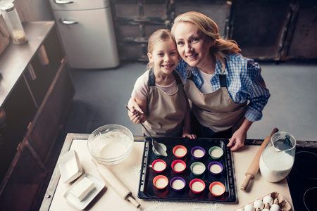 Top view of grandmother and granddaughter are cooking on kitchen. Making tasty baking together.の写真素材