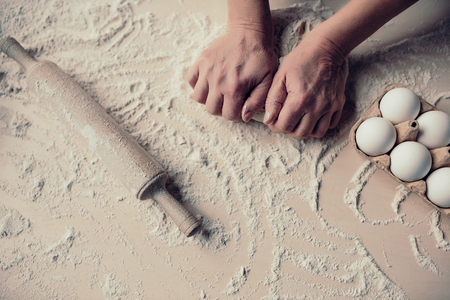 Cropped image of attractive senior woman is cooking on kitchen. Grandmother making tasty baking. Close-up of women's hands making dough.の写真素材