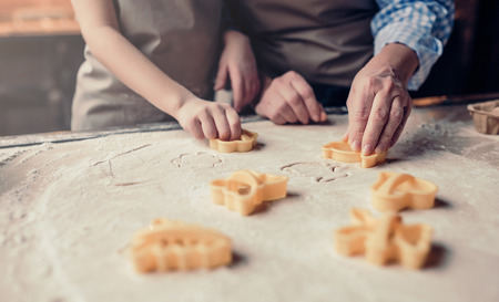 Cropped image of grandmother and granddaughter are cooking on kitchen. Making tasty baking together.の写真素材