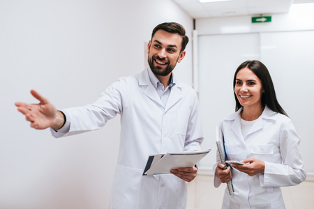 Two doctors are walking in the corridor of modern clinic.の写真素材