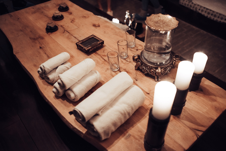 Spa and wellness center stuff. Candles and towels on wooden table.の写真素材