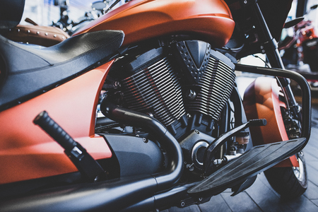 Cropped image of new motorcycle in shop. Motorcycles and accessories in modern motorcycle custom store. Biker stuffの写真素材